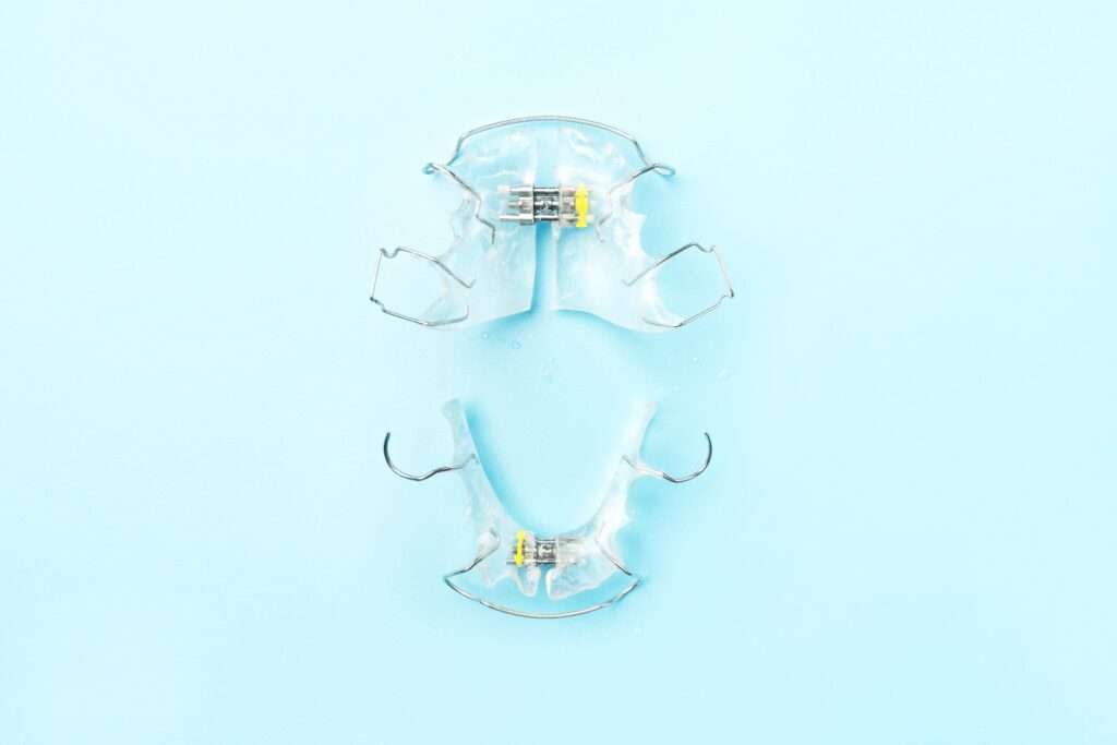 A set of clear top and bottom retainers against a blue background.