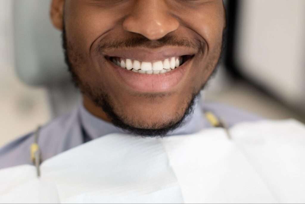 Man smiling in a dental exam chair. 