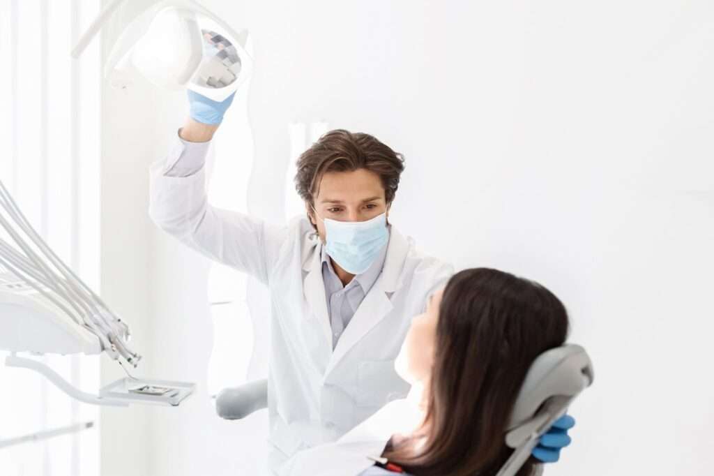 A man and woman in a dental office, discussing their treatment options with the dentist.