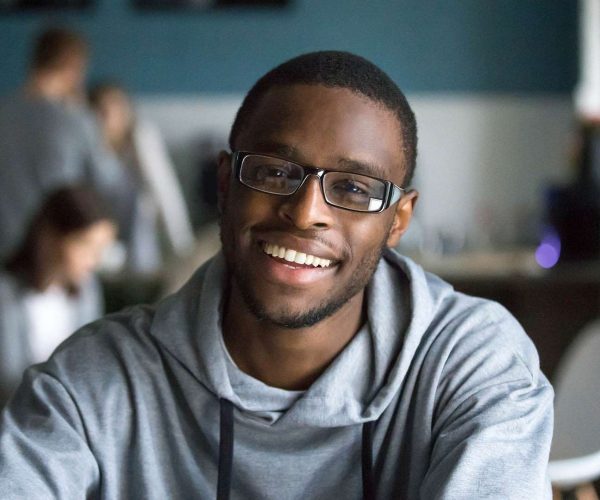 Portrait of smiling black man looking at camera in cafe